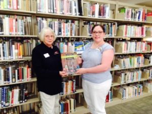 Astrid Ewing presenting a copy of the NC Extension Gardener Handbook to the Hendersonville Public Library