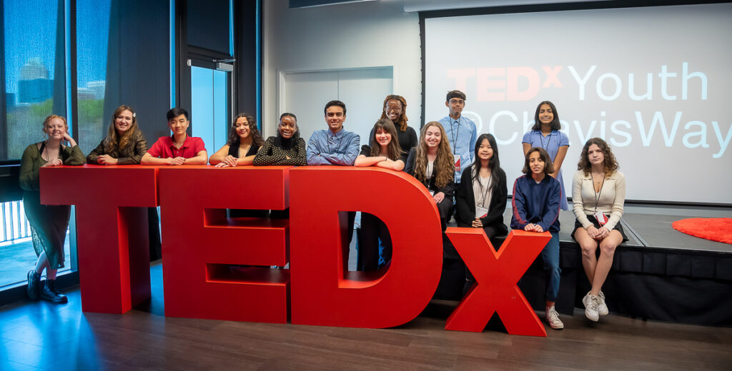 Youths pose with a TedX logo.