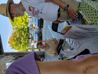 Two volunteers answer questions at the state farmers market.